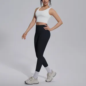Full body view of a white sports bra and high-waisted black yoga leggings set on model
