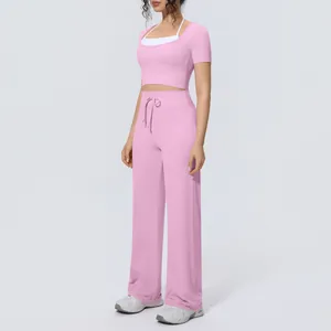 Side view of pink yoga outfit including short sleeve crop top and wide leg pants