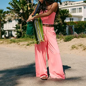 Detailed view of a pink yoga set with wide-leg pants and crop top in an outdoor setting