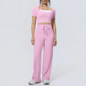 Stylish women's pink yoga set with short sleeve crop top and matching wide leg trousers
