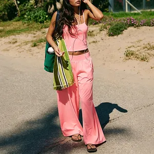 Close-up of pink two-piece yoga set featuring wide-leg pants and thin strap tank top.