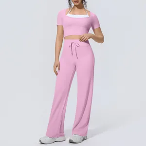 Close-up view of pink two-piece yoga set with halter neck top and wide-leg pants