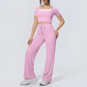 Women pink yoga set featuring short sleeve halter top and high waist wide leg pants