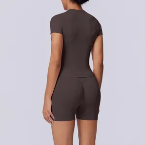 Achteraanzicht van een vrouw in een donkerbruine naadloze yogaset met korte mouwen