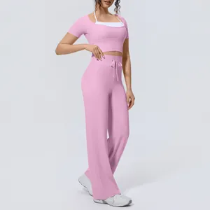 Two-piece pink yoga outfit with short-sleeved halter crop top and high-waist wide-leg trousers