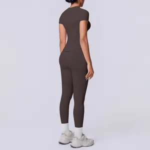 Rückansicht einer Frau im braunen nahtlosen Yoga-Set mit Kurzarm-Top und Leggings