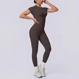 Eine fitte Frau in einem dunkelbraunen, nahtlosen, kurzärmeligen Yoga-Set für das Gym.