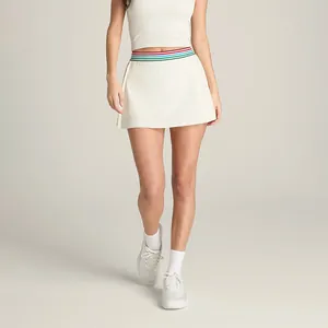 Gros plan d'une jupe de tennis plissée blanche avec une taille rayée colorée.