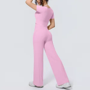 Back view of pink short-sleeve yoga top and matching wide-leg pants sports set on model