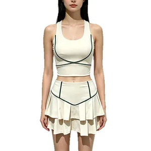 Conjunto de tenis crema para mujer con ribete verde, falda plisada y top de yoga.