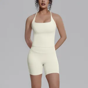 Crèmekleurige tweedelige atletische yogaset met haltertop en bikerbroekje met hoge taille