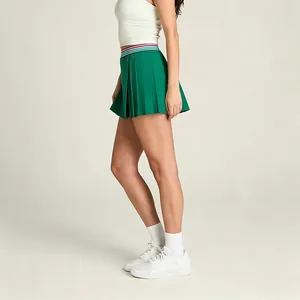 Vue détaillée d'une jupe de tennis plissée verte avec une ceinture à rayures.