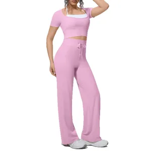 Pink two-piece yoga set featuring a short-sleeve crop top and wide-leg drawstring pants