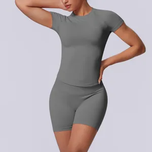 Gedetailleerd overzicht van grijze naadloze yoga-top en korte broek met hoge taille op model.