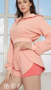 Détail d'un ensemble de sport rose avec sweat à capuche court et short deux-en-un