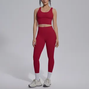 Woman in red two-piece seamless yoga set standing in professional studio setting