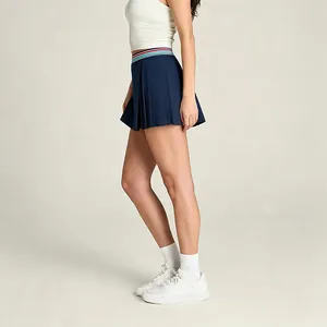 Détail latéral d'une jupe de tennis plissée bleu marine avec ceinture rayée colorée