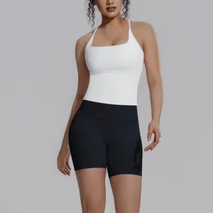 Vooraanzicht detail van een witte sporttanktop met vierkante hals en zwarte yogashort.