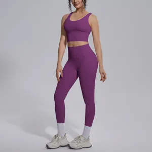 Model wearing purple two-piece yoga set with V-neck sports bra and high-waisted leggings.