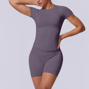 Detailopname van naadloze paarse yogaset met slimfit shirt met korte mouwen en shorts