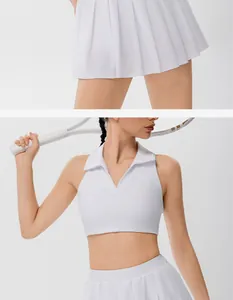Dettaglio del completo da tennis bianco da donna con polo corta e gonna a pieghe