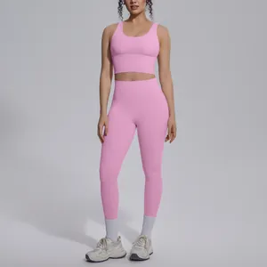 Pink yoga set for women with U-neck sports bra and high waisted leggings detail view.