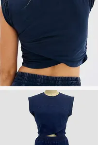 Close-up of navy blue sleeveless crop top with crossover hem detail and knit fabric