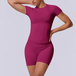 Detail van naadloze magenta yogaset met slim-fit shirt en korte broek met hoge taille