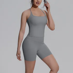 Gedetailleerd overzicht van een vrouw in een grijs tweedelig yogapak met tanktop en shorts.