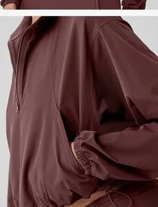 Detailed view of maroon half-zip sports sweatshirt with elastic cuffs and pocket.