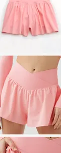 Détail d'un short de sport rose présentant une taille en V et un design à volant.