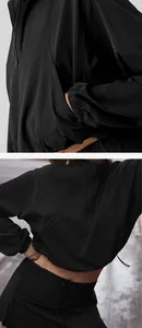 Detail view of women's black half-zip sports sweatshirt with drawstring and pockets