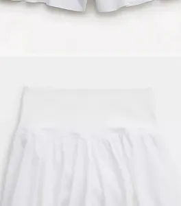 Détail d'un short de sport blanc à taille haute avec une large ceinture élastique et plis.