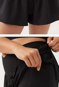 Detalle de falda deportiva de yoga negra con cintura cruzada y bolsillo lateral