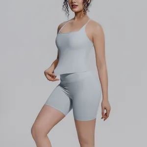 Model in een lichtblauw yoga-setje met strappy tanktop en strakke korte broek