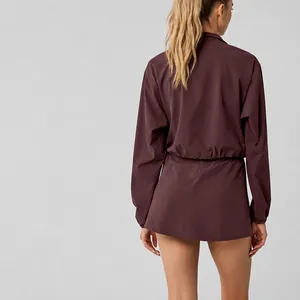 Back view of women's half-zip sports sweatshirt and matching skirt set in burgundy