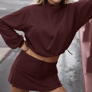 Maroon athletic set featuring a half-zip pullover and matching skort for women's fitness.