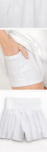 Detalle de falda pantalón de yoga blanca con cintura cruzada y bolsillo.