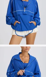 Close-up detail of blue half-zip athletic jacket with white piping and stand collar