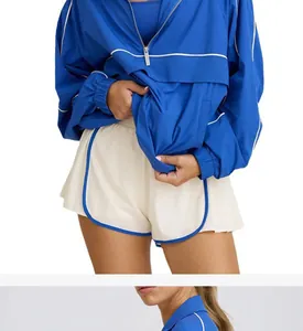 Close-up of blue half-zip sport jacket and cream athletic shorts for active women