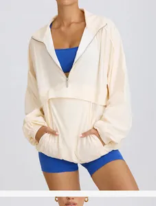 Close-up detail of a cream half-zip stand-up collar sports windbreaker for women's fitness