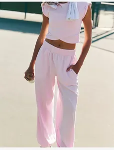 Women's pink two-piece sports set with sleeveless crop top and wide-leg pocket pants