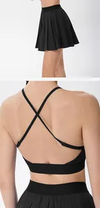 Vue détaillée d'un soutien-gorge de sport à dos croisé noir et jupe de tennis plissée.