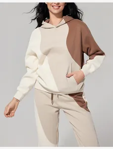 Vista dettagliata di una donna con un elegante completo felpa e pantaloni beige e marrone
