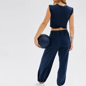 Women's navy two-piece sportswear set with sleeveless cross-back crop top and joggers