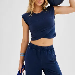 Women's navy two-piece sports set featuring sleeveless crop top and joggers with pockets.