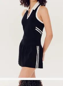 Side view of contrast polo neck sports top and tennis skirt set in black and white