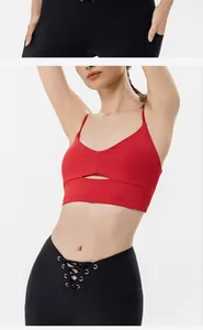 Primo piano di un reggiseno sportivo rosso con cut-out e leggings da yoga stringati.