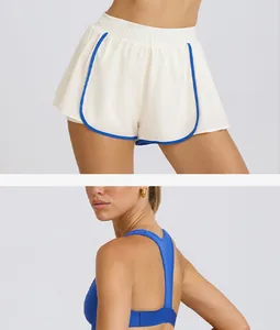 Detalle de pantalones cortos de yoga blancos plisados con ribete azul y sujetador