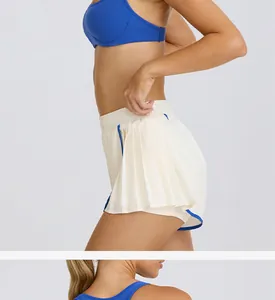 Detalle de pantalones cortos de yoga blancos plisados de cintura alta con ribete azul.